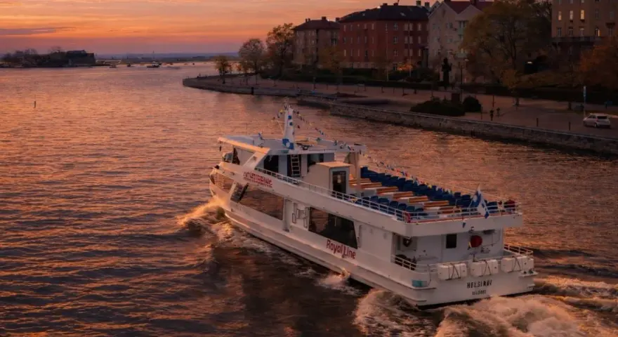 Prom Royal Line "Helsinki" płynie po wodzie podczas zachodu słońca, tworząc fale.