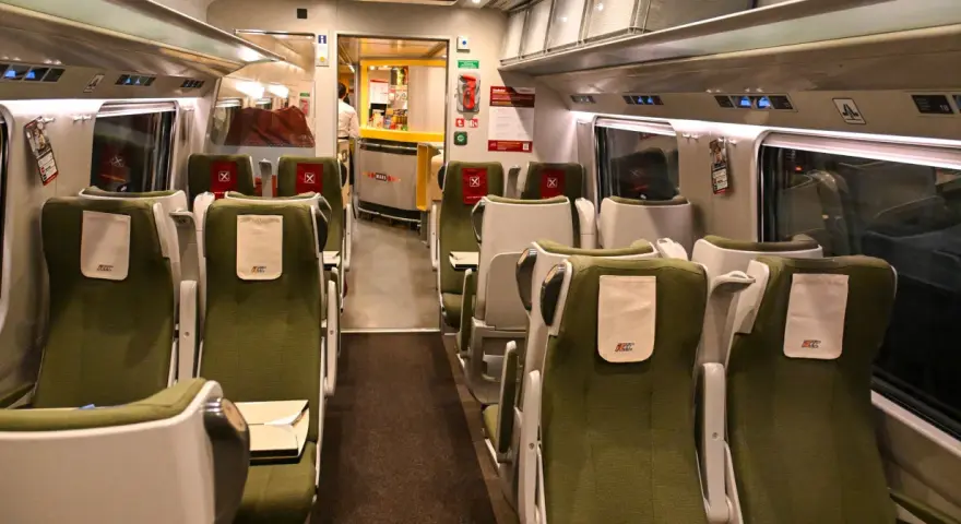 Wnętrze wagonu PKP Intercity IC 4520 Hutnik. Rozkład miejsc w zielonych fotelach, z widocznym barem Wars.