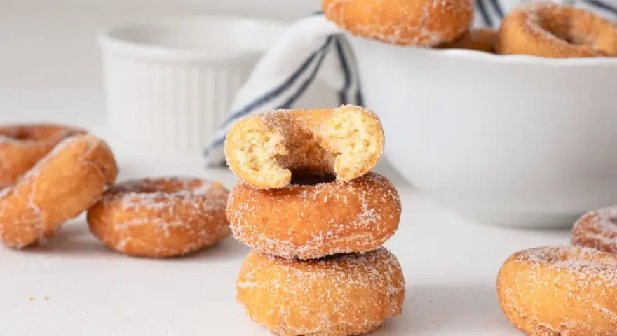 Rosquillas caseras de toda la vida, doradas y espolvoreadas con azúcar. Un bocado dulce que evoca recuerdos.