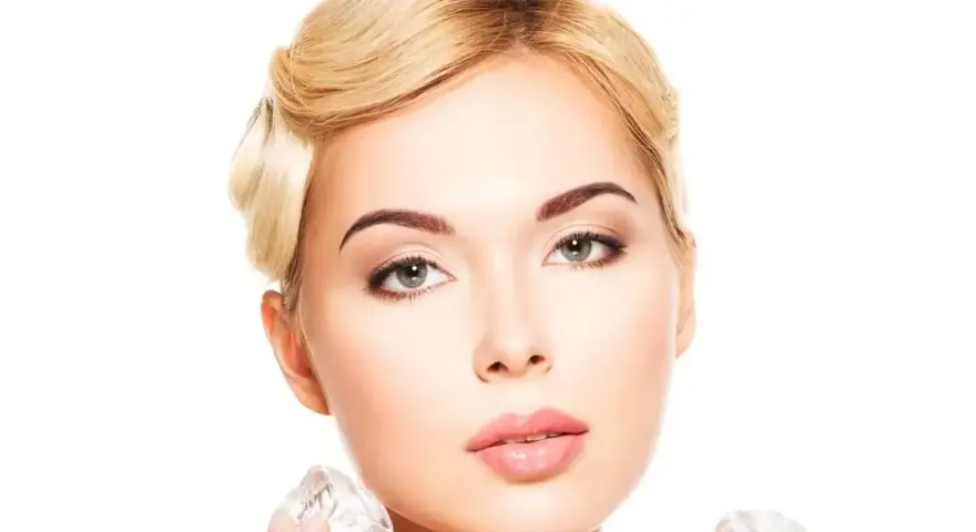 Kobieta z blond włosami stosuje lód na pryszcze, aby uzyskać gładką cerę.