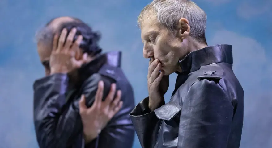 Kjell Brutscheidt, con le mani sul volto, esprime angoscia. L'altro uomo, sfocato, si copre le orecchie.