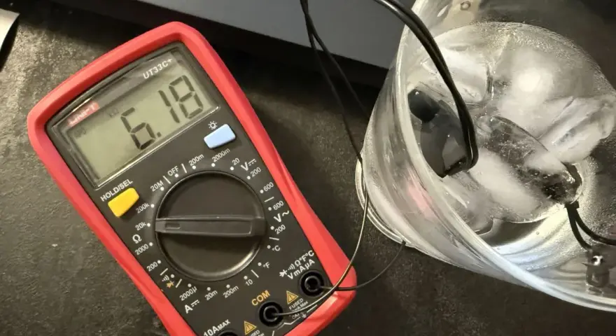 Multimetr pokazuje 6.18 kΩ, sprawdzając jak działa czujnik temperatury zewnętrznej w lodzie.