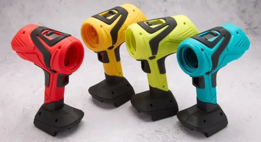Spools of colorful 3D printing filament and containers of material on a wooden surface.