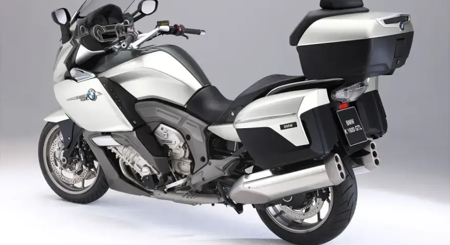 Srebrny motocykl BMW K1600GTL z kuframi i podnóżkami. Idealny do długich podróży, sprawdź jego bmw k1600gtl dane techniczne.