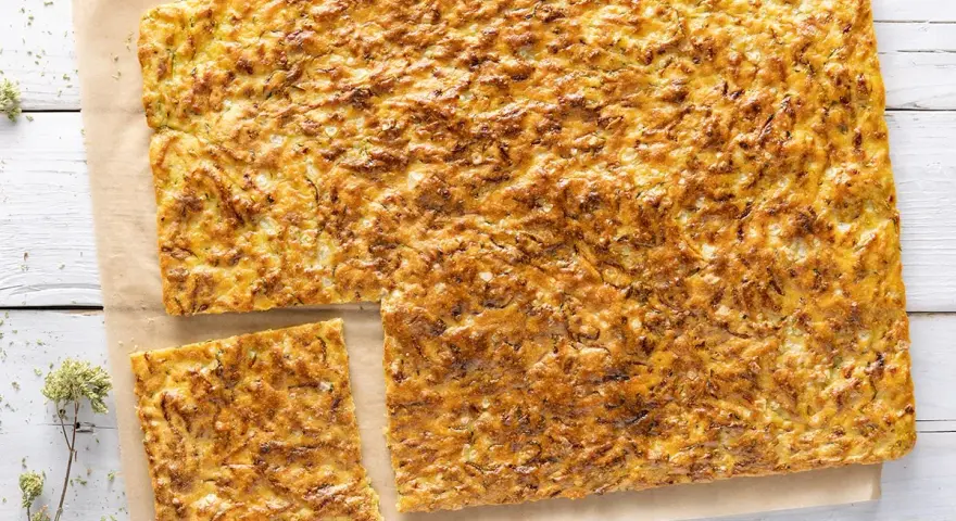 Una dorata schiacciata di zucchine, croccante fuori e morbida dentro, pronta per essere gustata.