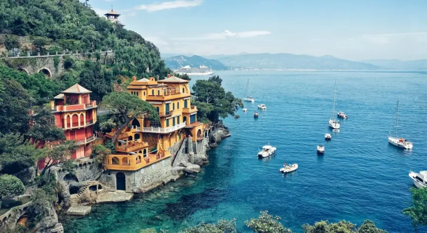 Bunte Häuser am Hang über dem türkisfarbenen Meer, Boote schaukeln im Wasser. Ein Traumziel für jeden Campingplatz Italien!