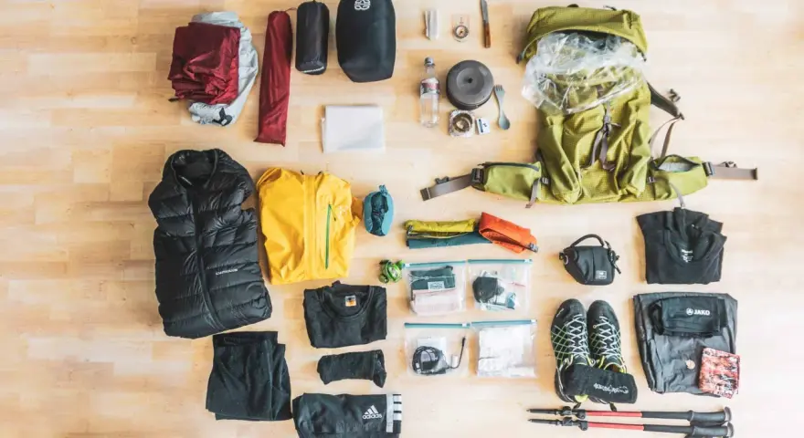 Rucksack, Zelt, Schlafsack, Jacken, Schuhe, Wanderstöcke und weitere Ausrüstung für eine perfekte backpacking packliste.