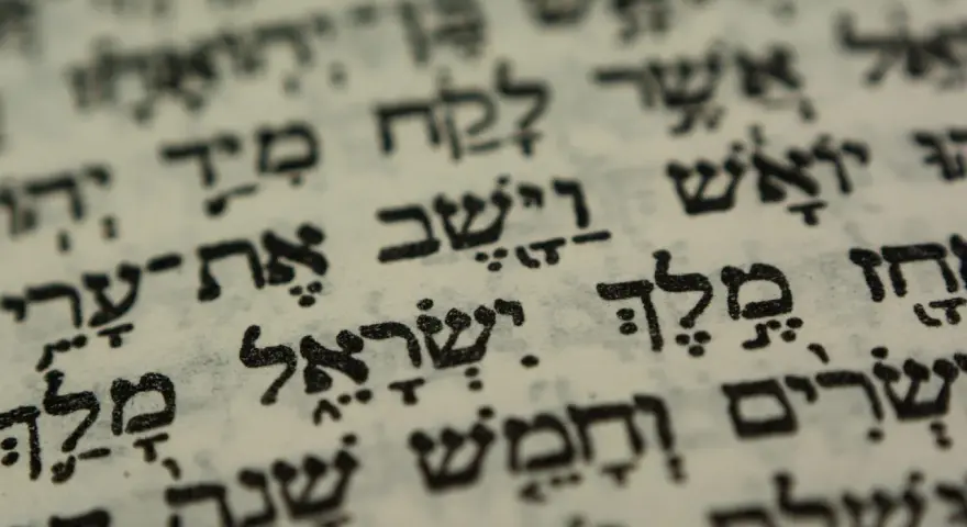 Close-up of Hebrew text on aged paper, hinting at the biblical meaning of Israel through ancient scripture.