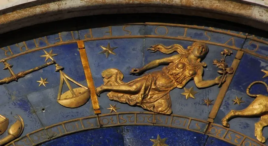 Złota postać z kwiatami, symbol znaku zodiaku Panna, obok wagi i lwa. 24.08 znak zodiaku.