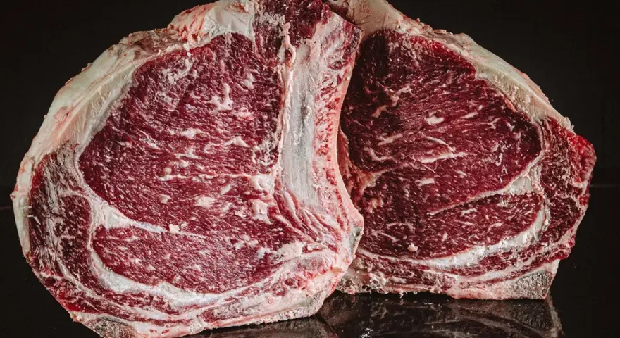 Dwa soczyste steki z wołowiny kobe, z widocznym marmurkowaniem, gotowe do grillowania.