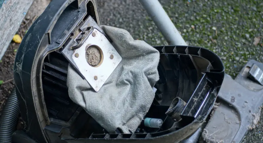 Ein staubsauger beutel wechseln ist nötig. Der alte, volle Beutel liegt offen, bereit für den Austausch.