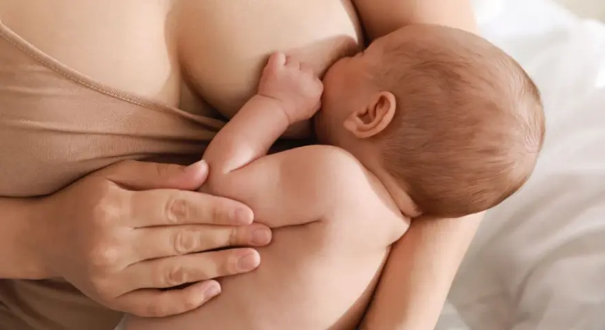 Un neonato si nutre al seno, ricevendo il prezioso colostro, un dono naturale per la sua crescita.
