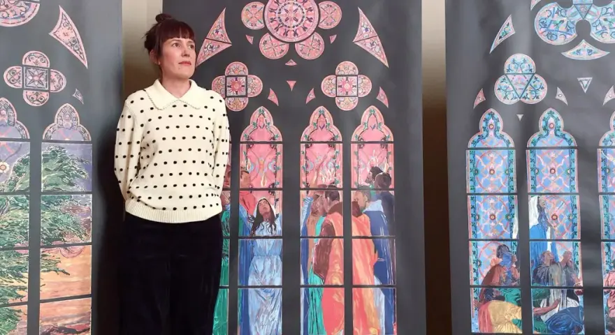 Une femme pose devant des vitraux stylisés, évoquant les vitraux de Notre Dame. Les scènes colorées représentent des figures humaines et des motifs floraux.