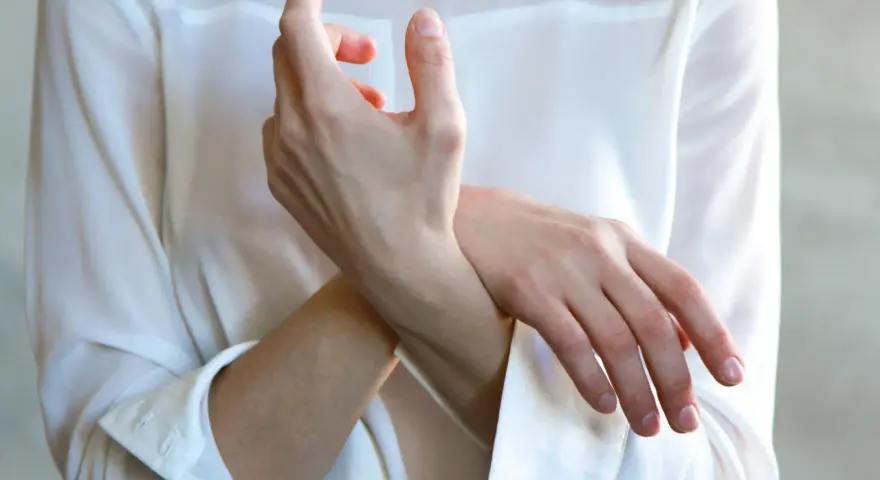 En person håller sin handled, möjligen på grund av inflammation i senskidan.