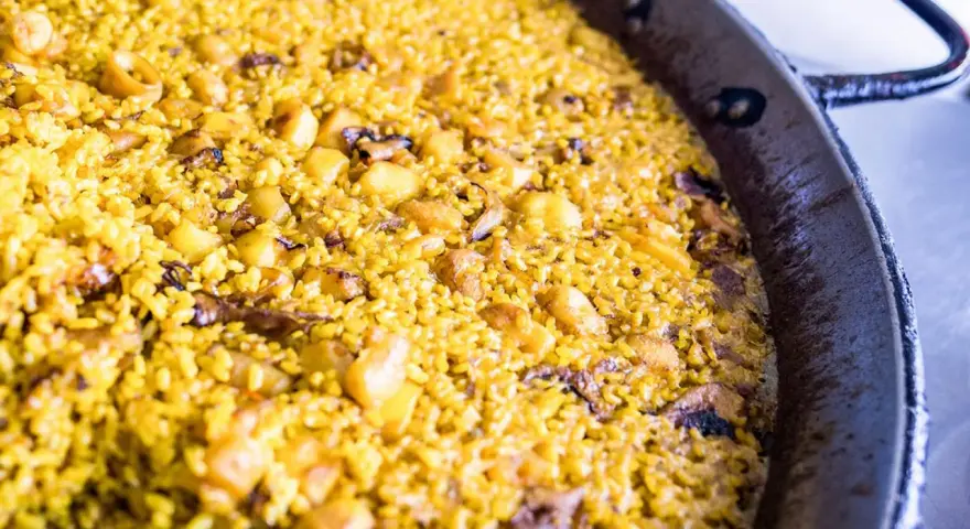 Arroz a banda recién hecho, con trozos de patata y marisco, listo para disfrutar.