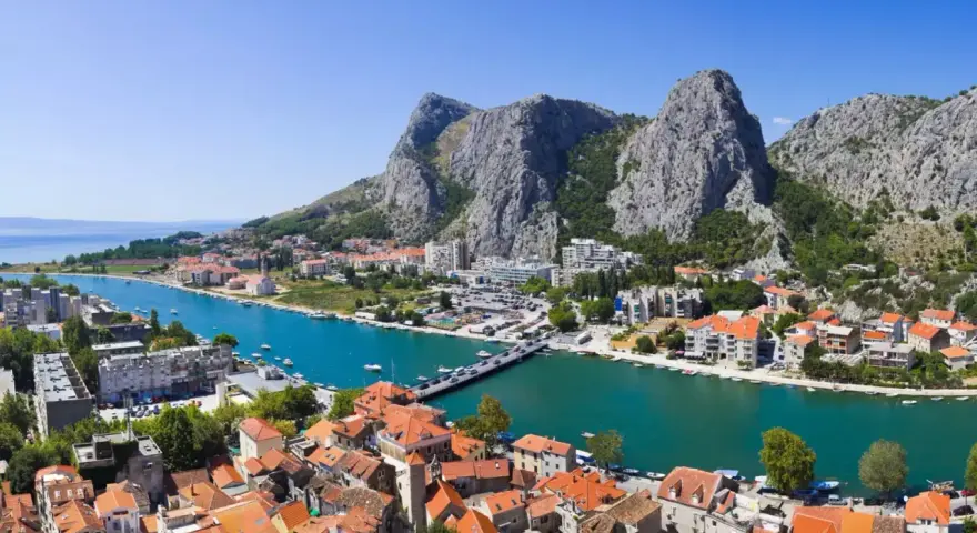 Widok na miasto Omiš w Chorwacji, gdzie rzeka Cetina wpada do morza. Piękne, turkusowe morze i góry.