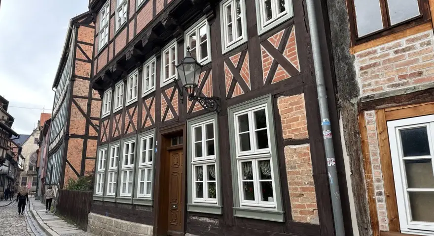 Vackra korsvirkeshus i Tyskland kantas av en kullerstensgata. De mörka träbjälkarna och tegelväggarna skapar en historisk atmosfär.