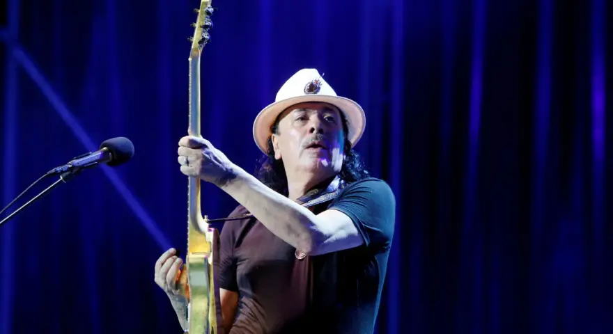 Carlos Santana z gitarą, gotowy do wykonania swoich niezapomnianych utworów.