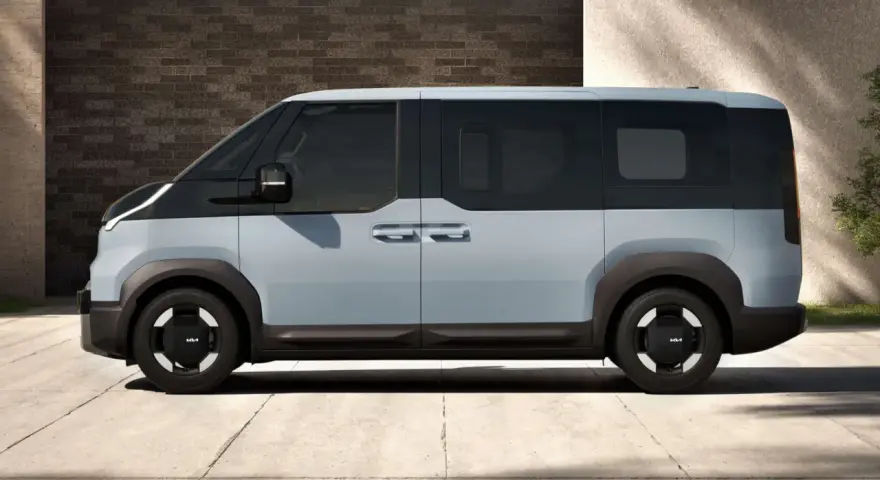 Jasnoszary elektryczny van Kia PV5 z czarnymi akcentami, widziany z boku.