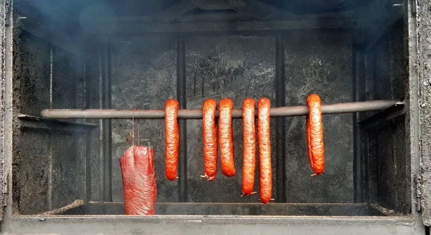 Kiełbasa wędzi się w dymie, tworząc apetyczny kolor. Idealna temperatura wędzenia kiełbasy to klucz do sukcesu.