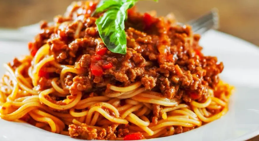 Pyszne spaghetti bolognese, idealne na prosty obiad. Aromatyczny sos mięsny z pomidorami i bazylią na złocistym makaronie.