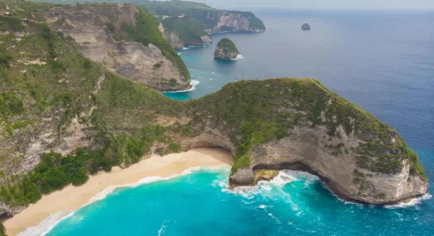 Widok z lotu ptaka na klify, piaszczystą plażę i turkusowe morze na Bali.