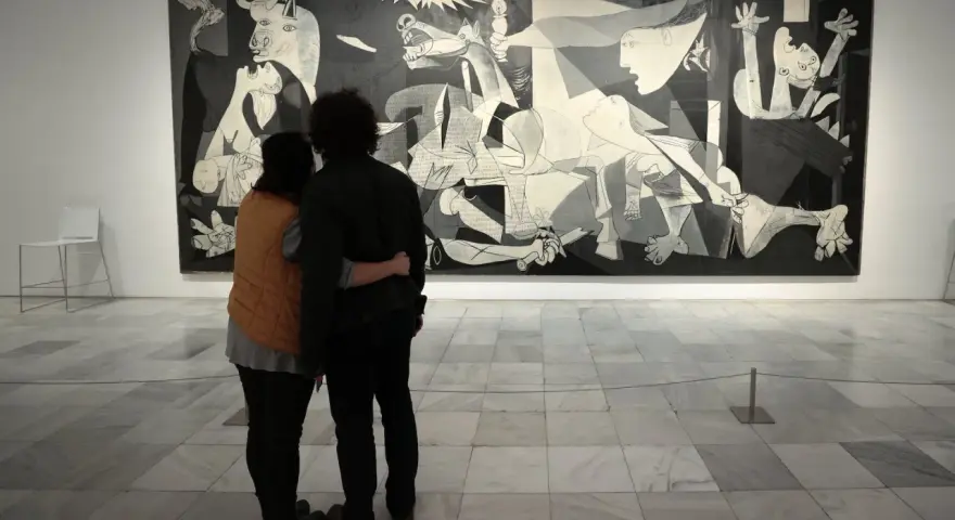 Para ogląda słynne **guernica obraz** Picassa, pełne bólu i chaosu.
