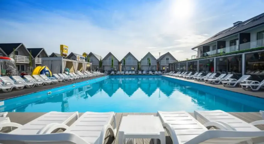 Słoneczny basen z leżakami w holiday park & resort Grzybowo. Opinie o tym miejscu są świetne!