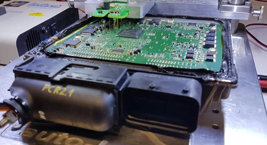 Naprawa sterownika silnika PCR2.1, który powodował wypadanie zapłonu. Widoczna płyta główna z elementami elektronicznymi pod specjalistycznym uchwytem.
