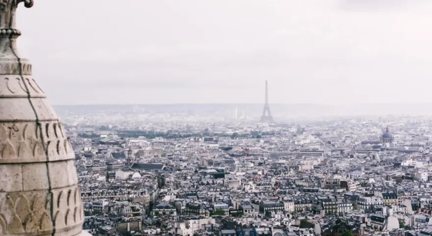 Vista panorámica de París con la Torre Eiffel al fondo. La arquitectura de la ciudad evoca un sentimiento de "enchanté significado".