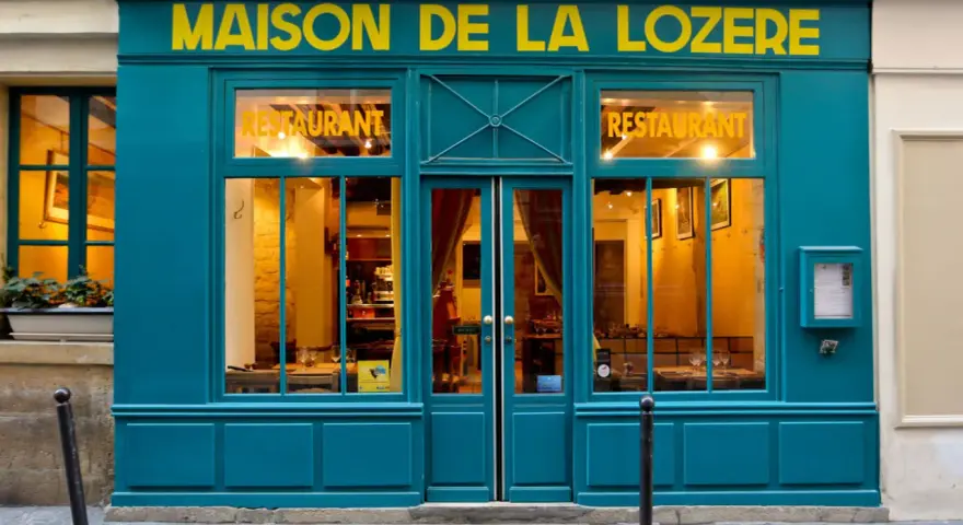 Maison de la Lozère, un ristorante accogliente dove mangiare a Parigi. L'insegna gialla risalta sulla facciata turchese.