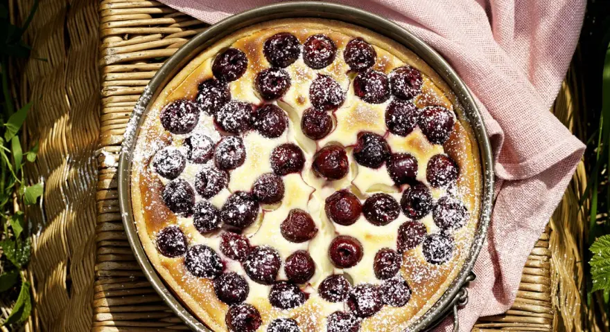 Ein köstlicher Kirschkuchen, bestäubt mit Puderzucker. Perfekt für sommerliche sauerkirschen rezepte.