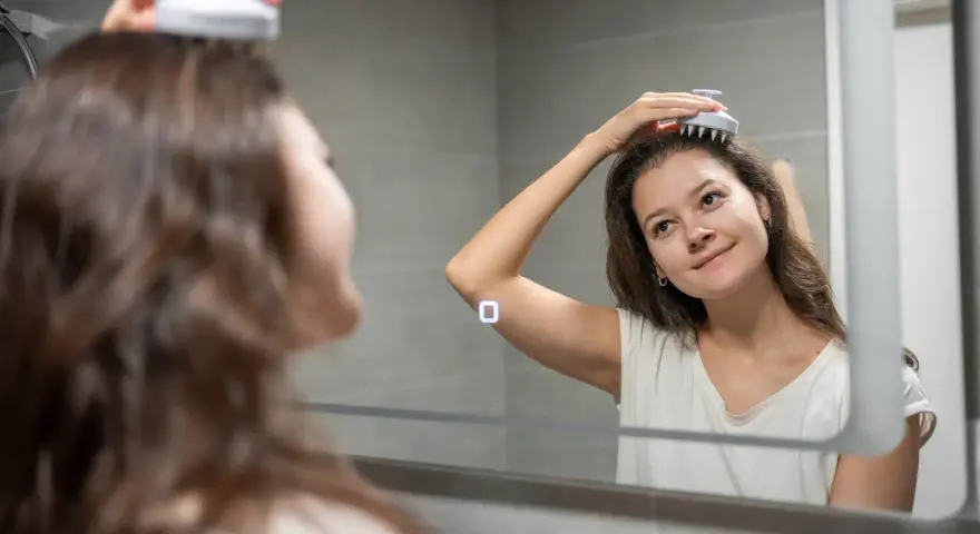 En kvinna njuter av en avkopplande hår massage framför spegeln.
