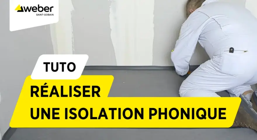 Tuto : réaliser une isolation phonique sur carrelage existant. Un ouvrier en combinaison blanche installe un revêtement gris au sol.