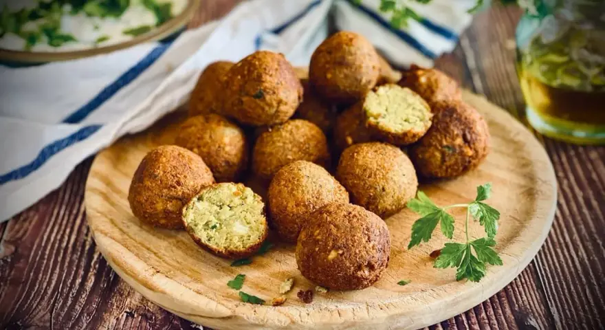 Frisch zubereitete Falafel auf einem Holzbrett, perfekt zum falafel selber machen. Ein Genuss für jeden Liebhaber der orientalischen Küche.