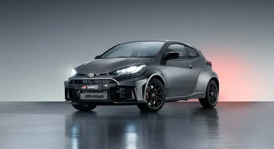 Szary Toyota GR Yaris GR-FOUR z agresywnym przednim zderzakiem i czarnymi felgami, gotowy do podboju dróg.