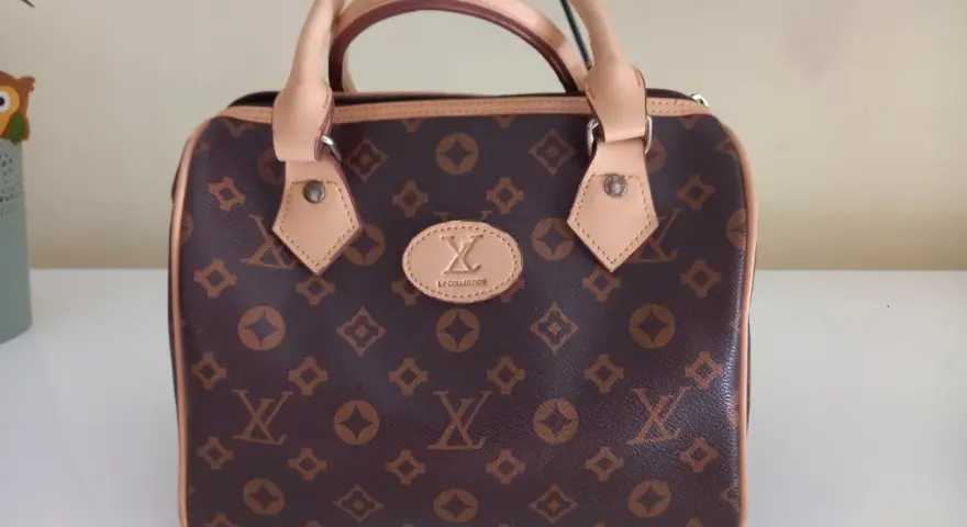Brązowa louis vuitton torebka kuferek z monogramem. Elegancka, z jasnymi rączkami i detalami.