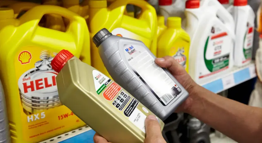 Wybierasz jaki olej do silnika? Na półce stoją różne marki: Shell Helix, Castrol Edge i Mobil Super.