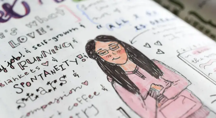 Rysunek w bullet journalu: uśmiechnięta dziewczyna w okularach i różowej bluzie, otoczona listą rzeczy, które kocha, jak bieganie i kawa.