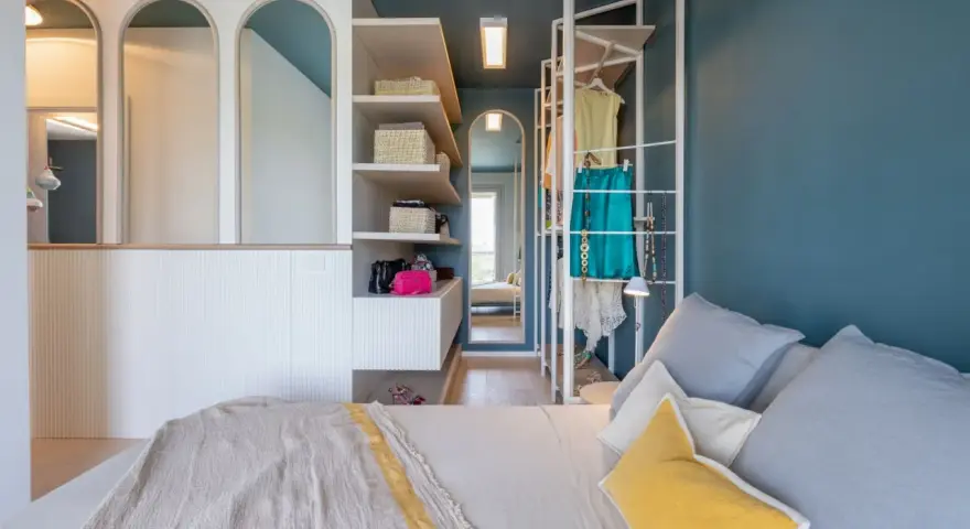 Progetto camera da letto con cabina armadio: letto, scaffali con cesti, abiti appesi e specchi ad arco.