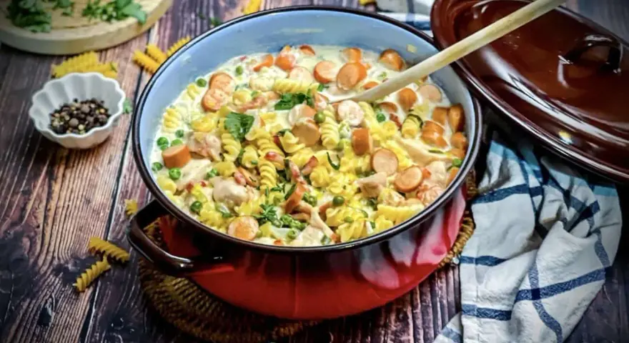 Herzhafte Nudelpfanne mit Würstchen, Erbsen und Hähnchen – ein Gericht, das perfekt für "das perfekte Dinner Rezepte" ist.