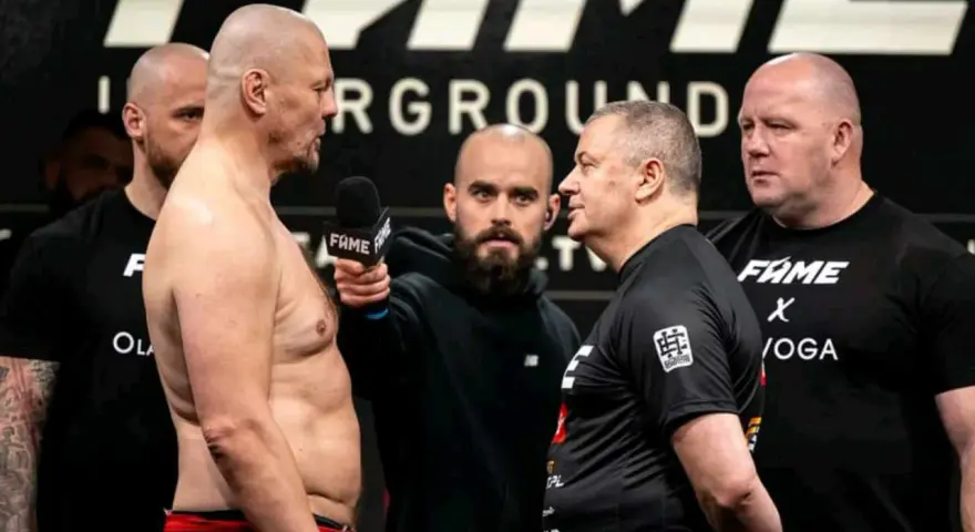 Dwóch zawodników na ważeniu przed walkami Fame MMA, z mikrofonem i ochroniarzami.