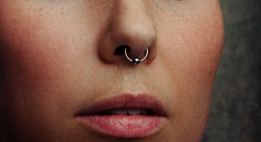 Zbliżenie na twarz z kolczykiem w nosie (septum). Czy septum boli? To pytanie zadaje sobie wiele osób przed piercingiem.