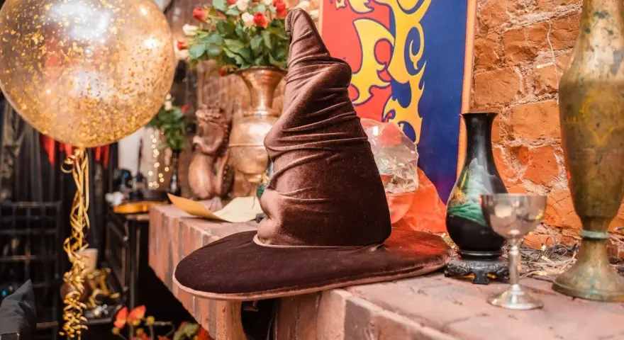 Czapka Mówiąca, złoty balon i bukiet róż tworzą magiczną atmosferę na weselu w stylu Harry'ego Pottera.
