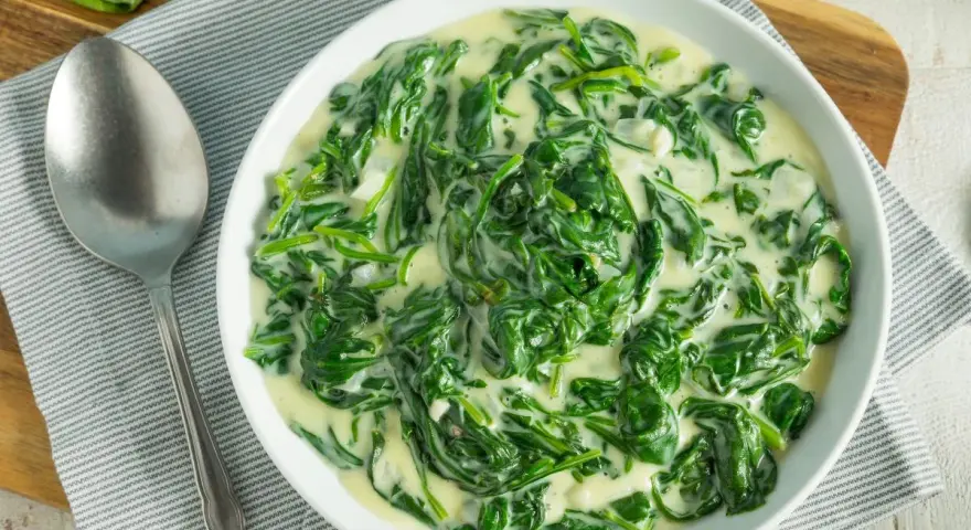 Un plato cremoso de espinacas con bechamel, listo para disfrutar.