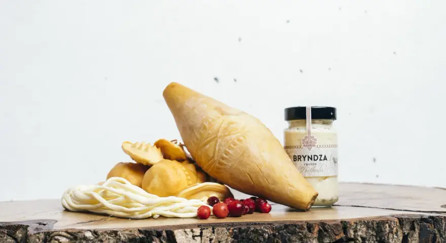 Góralskie sery, bryndza i żurawina na drewnianej desce.
