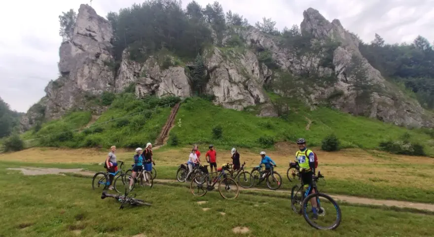 Grupa rowerzystów na tle skalnych ostańców. Jura Krakowsko-Częstochowska rowerem to wspaniała przygoda.