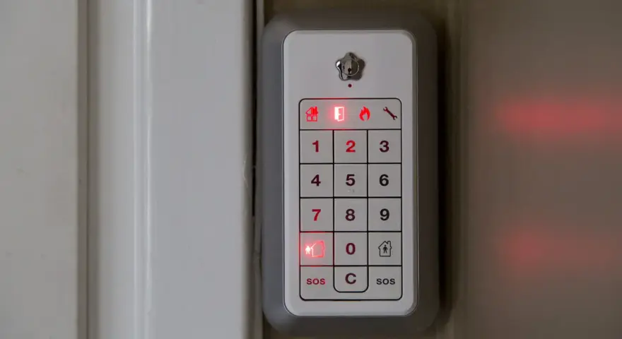 Verisure larma på med kod. En vit panel med siffror och symboler lyser rött.