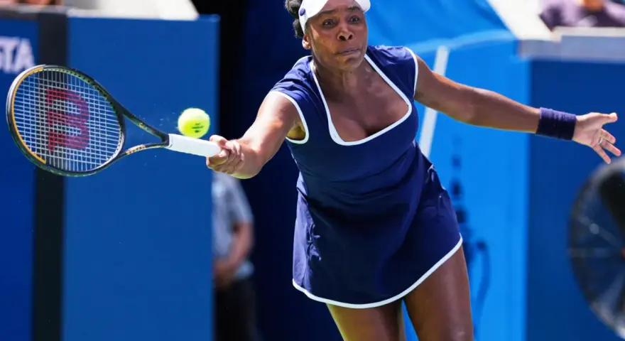 Venus Williams golpea la pelota en un partido, demostrando su destreza en los Grand Slams.