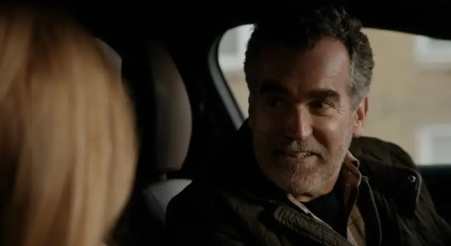 Un uomo sorride in auto, un momento di complicità nella serie turca "La Famiglia".